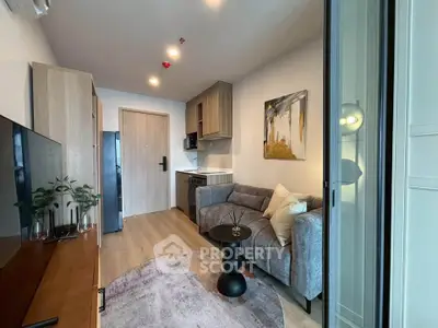 Modern living room with cozy sofa, stylish decor, and compact kitchen in open layout apartment.