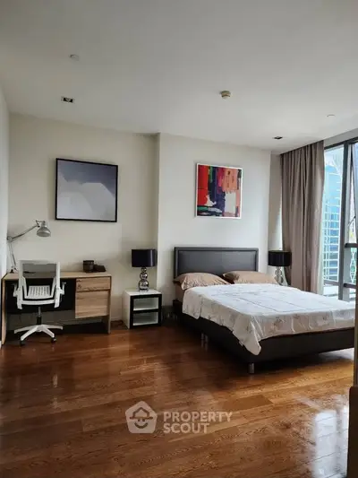 Spacious bedroom with modern decor and large window offering city views.
