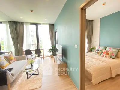 Modern living room with open layout and cozy bedroom, featuring stylish decor and natural light.
