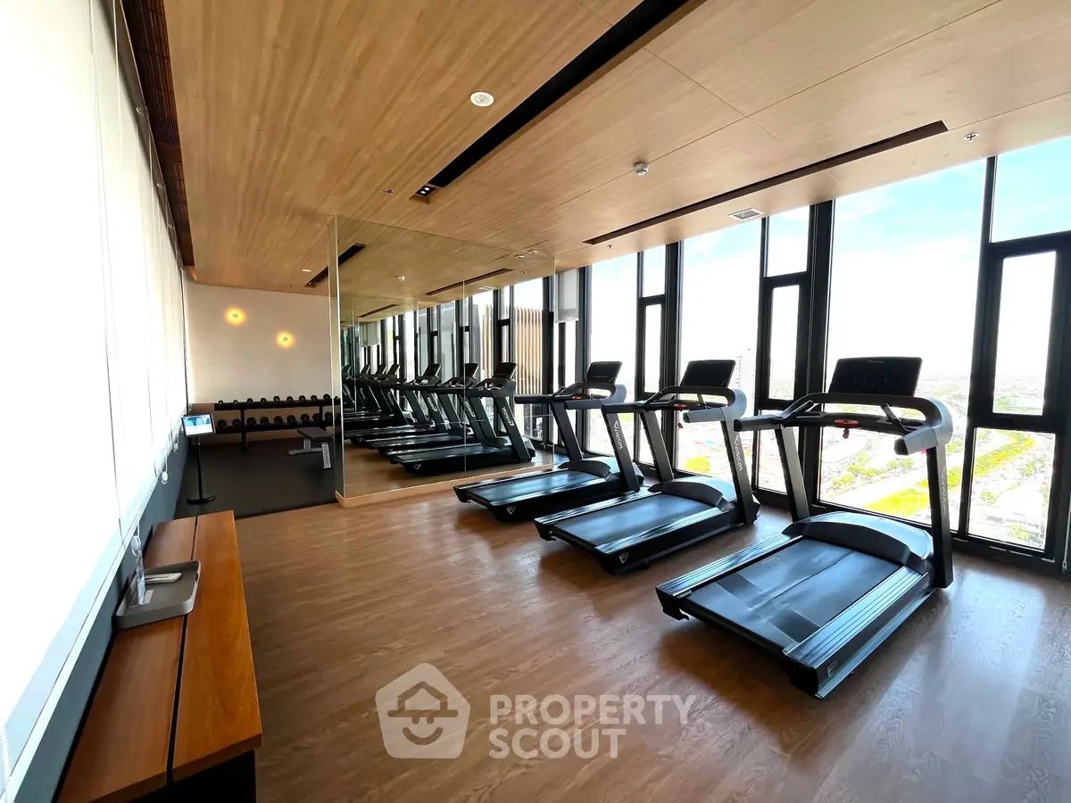 Modern gym with treadmills and large windows offering a scenic view, perfect for fitness enthusiasts.