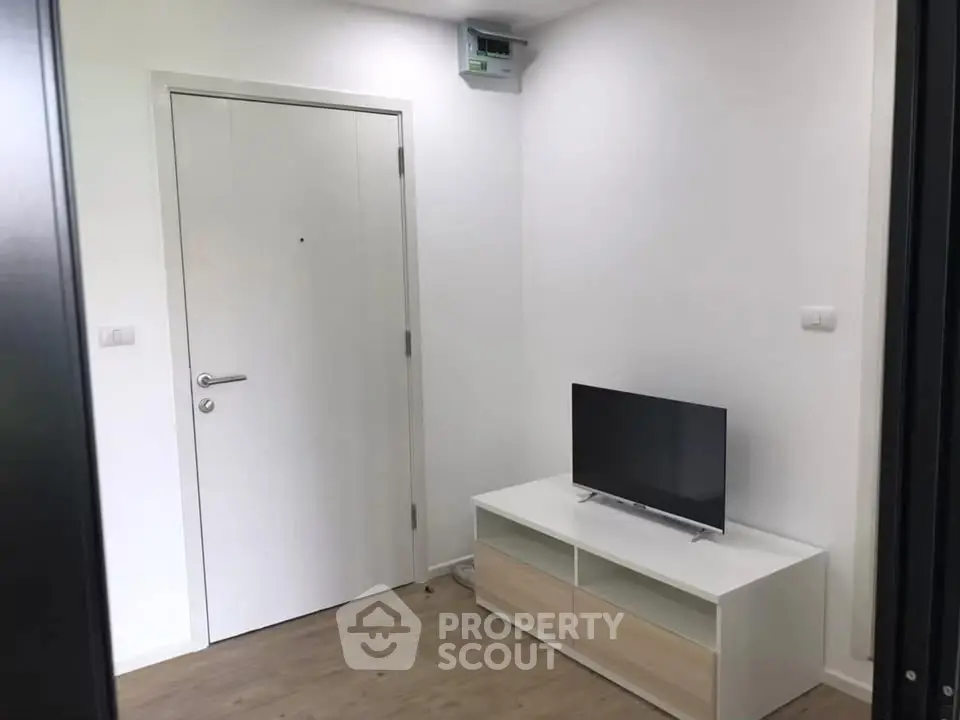 Modern minimalist living room with sleek TV stand and white door
