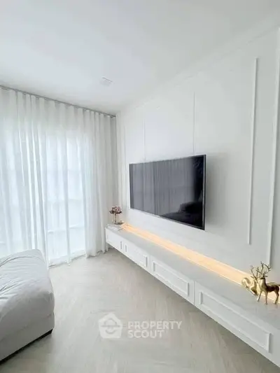 Modern living room with sleek TV setup and elegant white decor