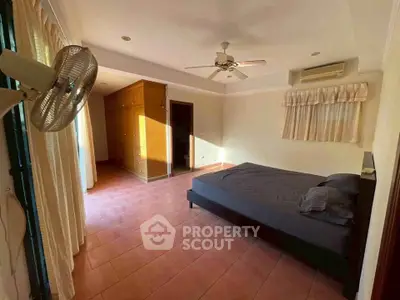 Spacious bedroom with natural light, ceiling fan, and air conditioning in a modern home.