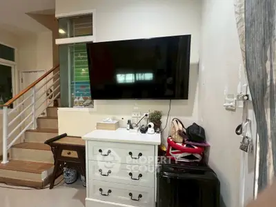 Cozy living room with wall-mounted TV and stylish white dresser, perfect for modern living.