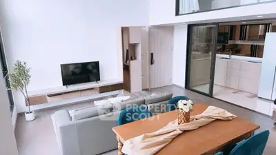 Spacious modern living room with open kitchen and elegant dining area, perfect for entertaining.