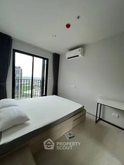 Modern bedroom with balcony view, featuring sleek design and natural light.