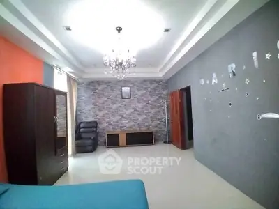 Spacious living room with modern decor and elegant chandelier in a stylish home.