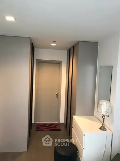 Modern hallway with sleek storage and stylish decor in a contemporary apartment.