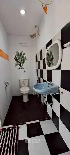 Chic black and white checkered bathroom with modern fixtures and tropical decor.