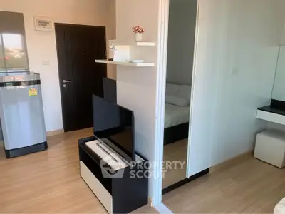Modern apartment interior with sleek TV stand and mirrored closet in cozy living space.