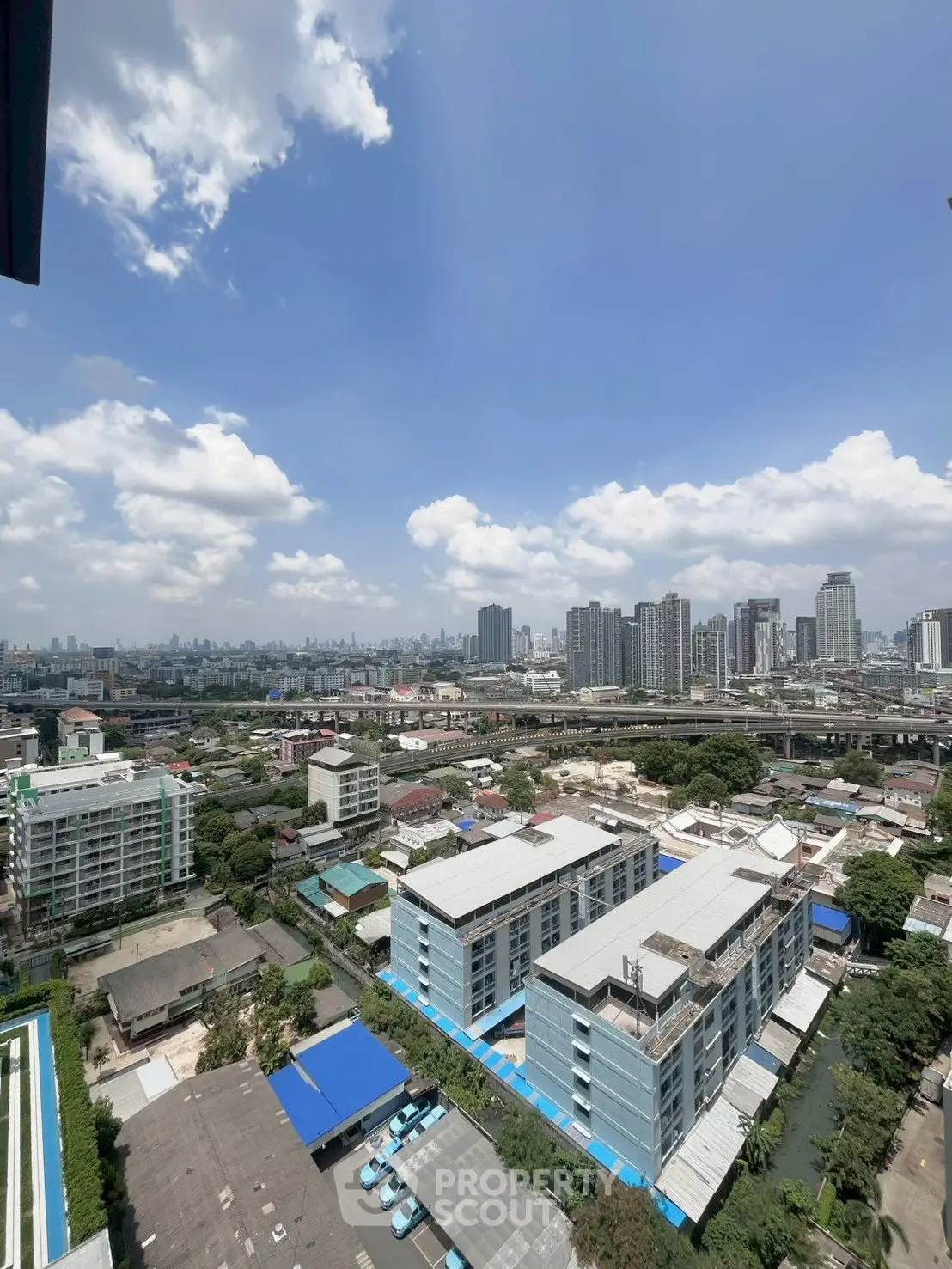 Stunning cityscape view from high-rise building showcasing urban skyline and blue sky.