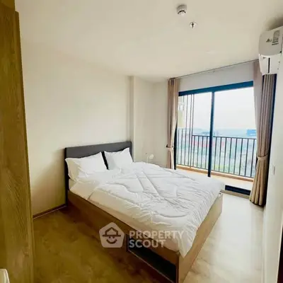Modern bedroom with large window and balcony view, featuring a cozy bed and wooden flooring.
