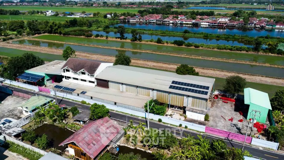 Aerial view of a rural property with solar panels and scenic surroundings.
