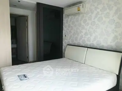 Modern bedroom with stylish wallpaper and air conditioning in a contemporary apartment.