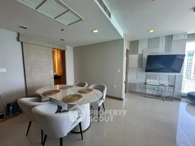 Modern living room with elegant dining area and wall-mounted TV in a high-rise apartment.