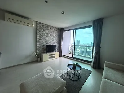 Spacious living room with modern decor and stunning city view from large balcony.