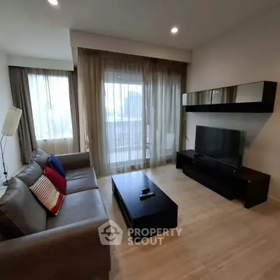 Modern living room with sleek furniture and large windows offering natural light.