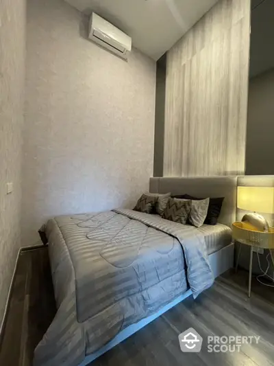 Modern bedroom with stylish decor and air conditioning in a cozy apartment.