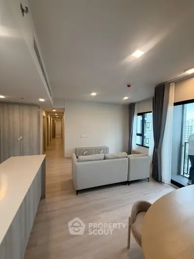 Modern living room with sleek design and large windows offering city views