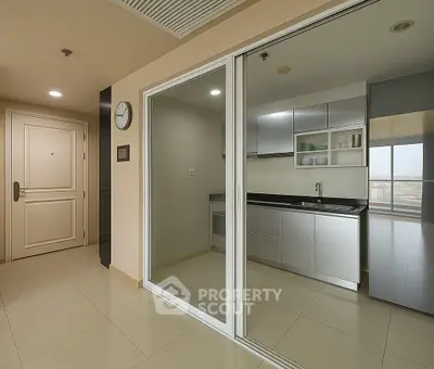 Modern kitchen with sleek cabinetry and glass partition in a contemporary apartment.