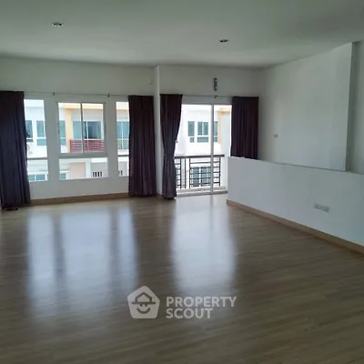 Spacious and bright living room with large windows and balcony access in modern apartment.