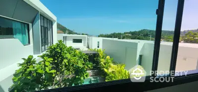 Modern villa with lush garden view through large window