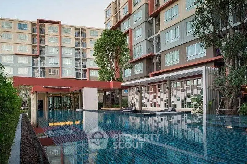 Modern apartment building with luxurious pool and lush greenery, offering a serene living environment.