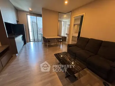 Modern living room with sleek furniture and city view from large window.