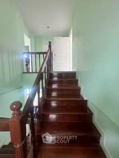 Charming wooden staircase with elegant railing in a cozy home interior.