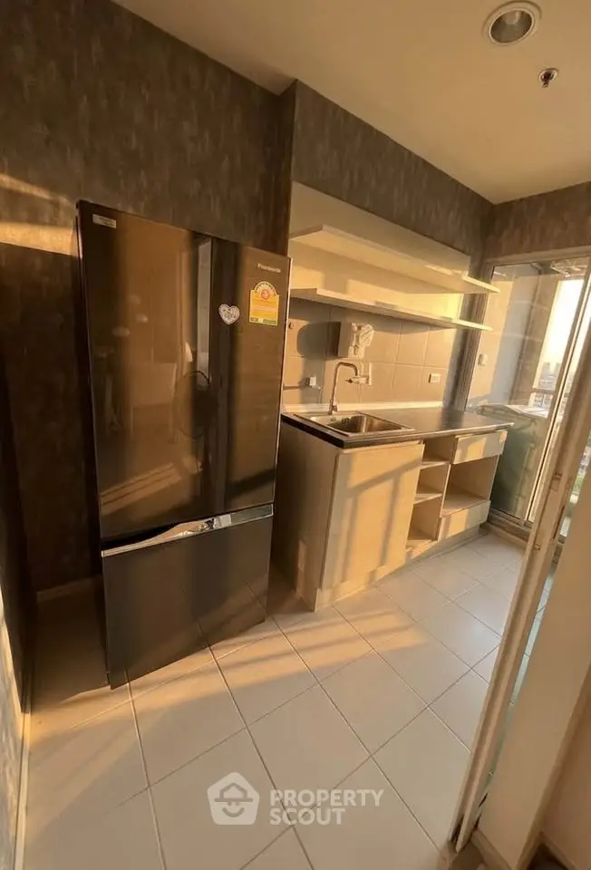 Modern kitchen with sleek black fridge and ample natural light