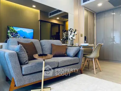 Modern living room with stylish sofa, dining area, and wall-mounted TV in a cozy apartment.