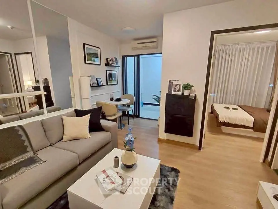 Modern living room with cozy decor and open view into a stylish bedroom, perfect for urban living.