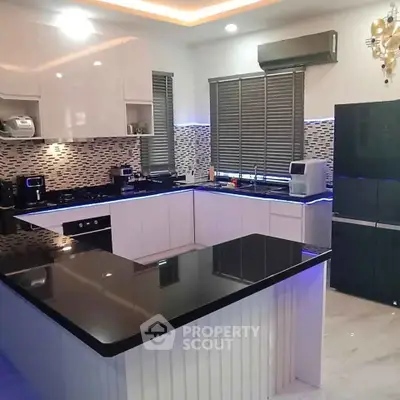 Modern kitchen with sleek black countertops and stylish backsplash