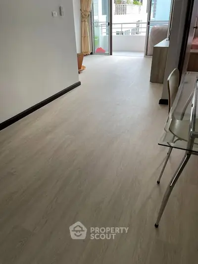 Spacious apartment with modern flooring and balcony access, ideal for urban living.