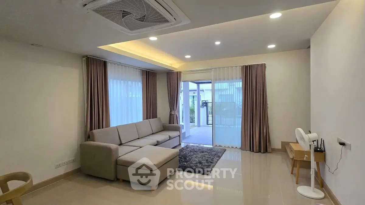 Spacious modern living room with elegant decor and large windows for natural light.