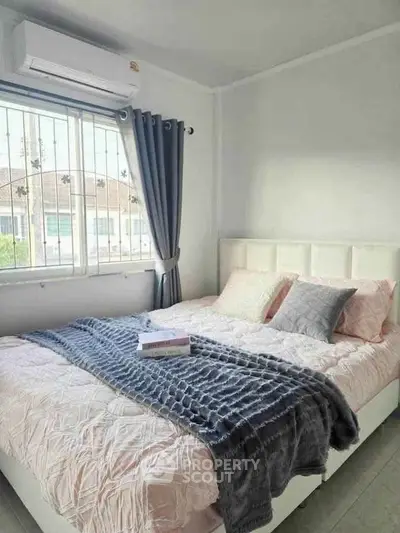 Cozy bedroom with large window and stylish decor in modern apartment.
