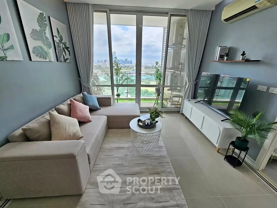 Modern living room with large windows and city view, featuring stylish decor and comfortable seating.