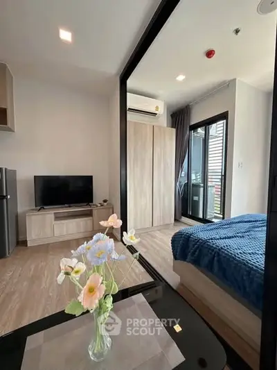 Modern studio apartment with cozy bedroom and living area, featuring a sleek design and natural light.
