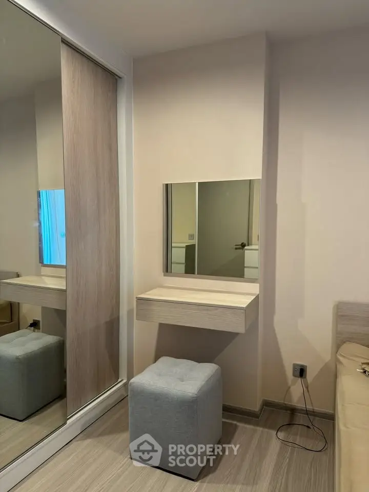 Modern bedroom with stylish vanity and mirrored closet doors