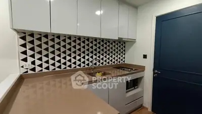 Modern kitchen with sleek cabinets and geometric backsplash design