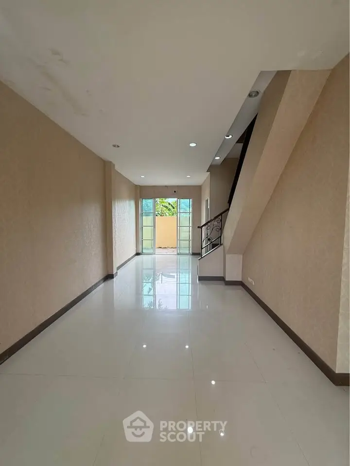 Spacious interior with glossy floors and large windows offering natural light, ideal for modern living.