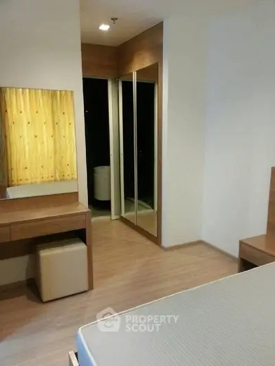 Modern bedroom with wooden flooring and mirrored closet doors
