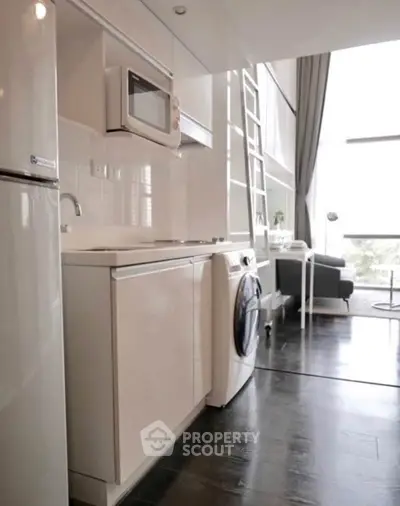Modern compact kitchen with washing machine and loft-style living area