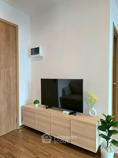 Modern living room with sleek TV stand and stylish decor in a cozy apartment.