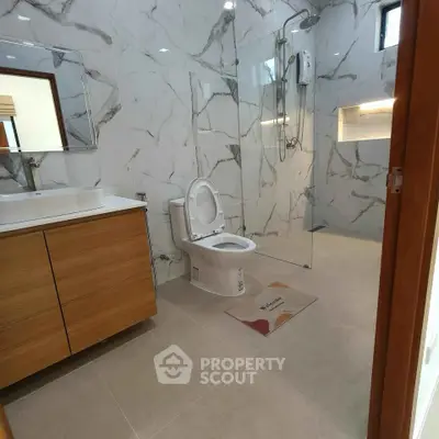 Modern bathroom with marble tiles and glass shower enclosure