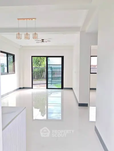 Spacious modern living room with large windows and sleek flooring, perfect for natural light and open living.