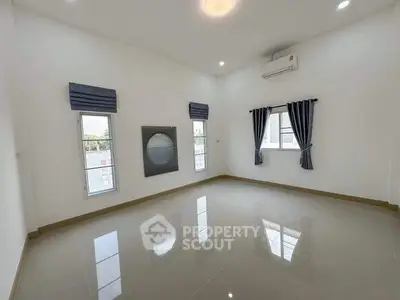 Spacious empty room with large windows and air conditioning unit