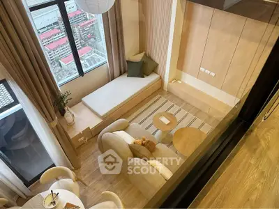 Modern living room with cozy seating and city view from large window.