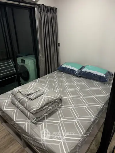 Cozy bedroom with modern decor and washing machine in a compact space.
