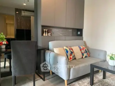 Modern living room with stylish sofa and vibrant cushions in a cozy apartment setting.